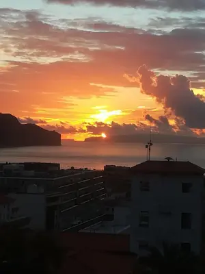 a sunset over a city with the ocean in the background at Cc39-Q6 in Funchal