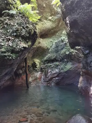 a pool of water in a cave with rocks at Cc39-Q6 in Funchal