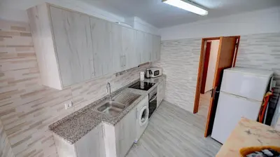 a kitchen with a sink and a white refrigerator at PRAINHA BEACH APARTMENT in Luz