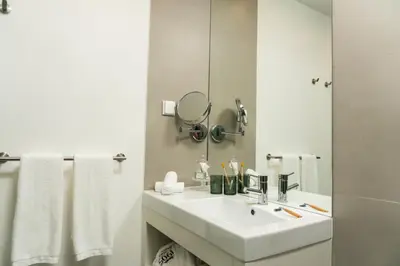 a white bathroom with a sink and a mirror at 1905 Zino's Palace in Ponta do Sol