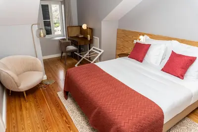 a bedroom with a bed and a chair and a desk at 1905 Zino's Palace in Ponta do Sol