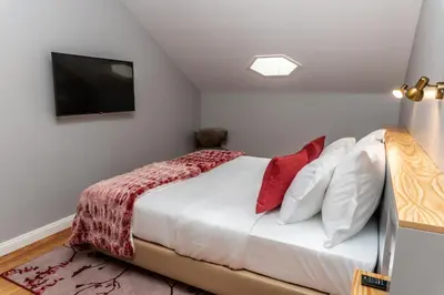 a bedroom with a bed with a television on the wall at 1905 Zino's Palace in Ponta do Sol