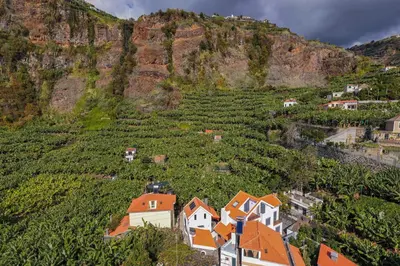 an aerial view of a village in front of a mountain at Oscar's House by An Island Apart in Ponta do Sol