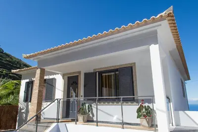 a white house with black shutters on a balcony at “VENIK HOUSE” sea_mountains_relaxing_barbecue in Funchal