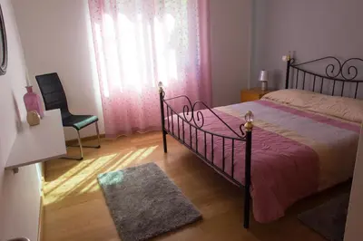 a bedroom with a bed and a chair and a window at “VENIK HOUSE” sea_mountains_relaxing_barbecue in Funchal