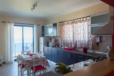 a kitchen with a table and a kitchen with a window at “VENIK HOUSE” sea_mountains_relaxing_barbecue in Funchal