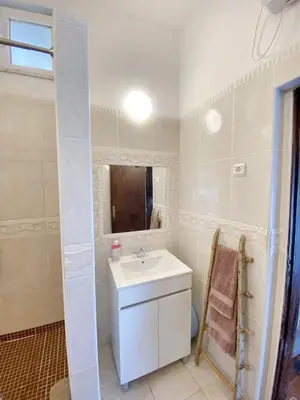 a white bathroom with a sink and a mirror at Charming House in Barão de São Miguel in Barão de São Miguel