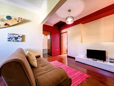 a living room with a couch and a flat screen tv at Domus Dino in Porto da Cruz