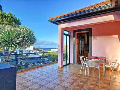 a patio with a table and chairs on a balcony at Domus Dino in Porto da Cruz