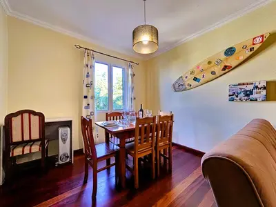 a dining room with a table and a surfboard on the wall at Domus Dino in Porto da Cruz