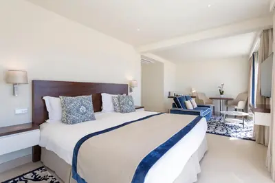 a hotel room with a large bed and a table at Residence Sol e Mar in Salema