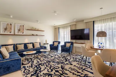 a living room with blue couches and a flat screen tv at Residence Sol e Mar in Salema