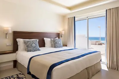a bedroom with a large bed with a view of the ocean at Residence Sol e Mar in Salema