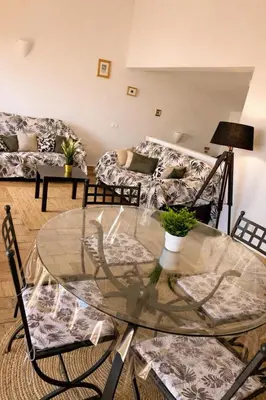 a living room with a glass table and chairs at Casadaluz 86 - Porto dona Maria casa do mar , 2 bedrooms , Amazing sea view , salt water pool , wifi in Luz