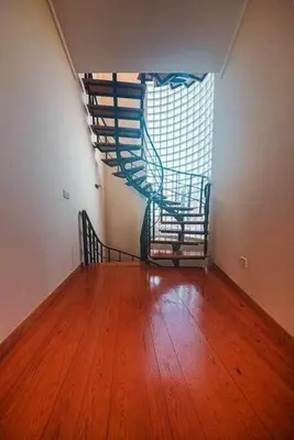 a room with a wooden floor and a spiral staircase at Casa da Terça - Nice View and Parking in Funchal