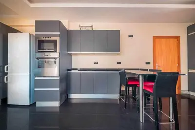 a kitchen with stainless steel appliances and a table with chairs at Casa da Terça - Nice View and Parking in Funchal