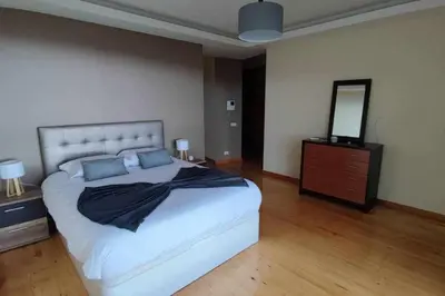 a bedroom with a large bed with a dresser and a mirror at Casa da Terça - Nice View and Parking in Funchal
