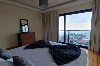 a bedroom with a large bed with a large window at Casa da Terça - Nice View and Parking in Funchal