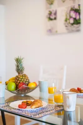 a glass table with a plate of food and fruit at Magnolia Apartment by Atlantic Holiday in Funchal