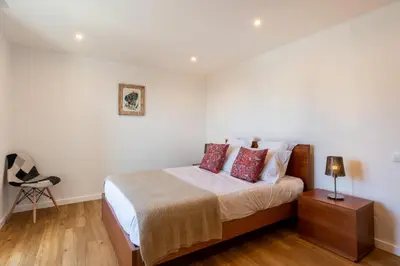 a bedroom with a bed and a chair in it at Magnolia Apartment by Atlantic Holiday in Funchal
