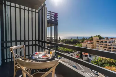 a balcony with a table and a chair and a view at Magnolia Apartment by Atlantic Holiday in Funchal