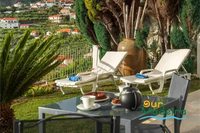 a table and chairs on a patio with a view at OurMadeira - Amaro Sol in Calheta