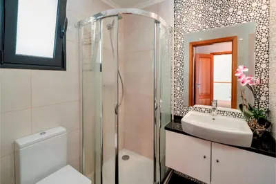 a bathroom with a glass shower and a sink at OurMadeira - Amaro Sol in Calheta