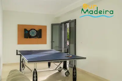 a ping pong table in the middle of a room at OurMadeira - Amaro Sol in Calheta