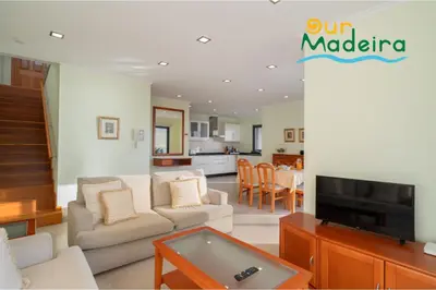 a living room with a couch and a tv at OurMadeira - Amaro Sol in Calheta