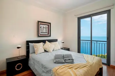 a bedroom with a bed with a view of the ocean at OurMadeira - Amaro Sol in Calheta