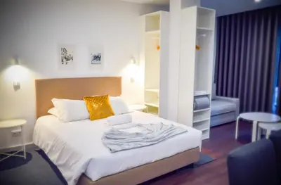 a bedroom with a bed with a yellow pillow on it at CBA Suites Madeira in Funchal