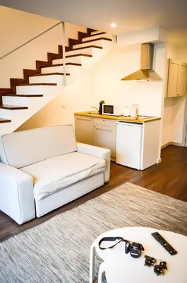 a living room with a white couch and stairs at CBA Suites Madeira in Funchal