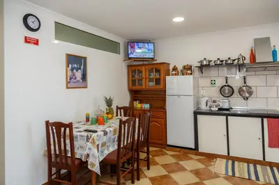 a kitchen with a table with chairs and a refrigerator at Residencia ANA Piso Zero 0 in Santa Cruz