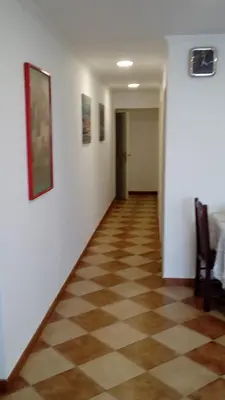 a hallway with white walls and a checkered floor at Residencia ANA Piso Zero 0 in Santa Cruz