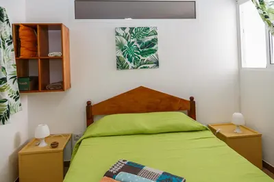 a bedroom with a green bed with two night stands at Residencia ANA Piso Zero 0 in Santa Cruz