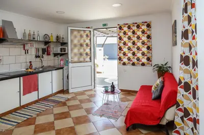 a living room with a red couch and a kitchen at Residencia ANA Piso Zero 0 in Santa Cruz
