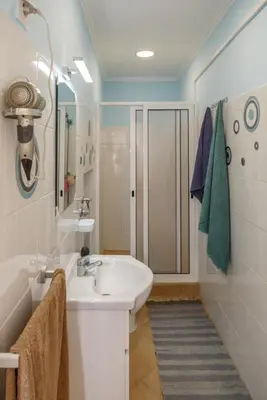 a white bathroom with a sink and a shower at Residencia ANA Piso Zero 0 in Santa Cruz