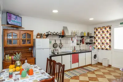 a kitchen with a table and a white refrigerator at Residencia ANA Piso Zero 0 in Santa Cruz