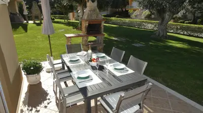 a wooden table with white chairs and a grill at LakeView Boavista in Lagos
