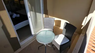 a room with two chairs and a table and a bed at LakeView Boavista in Lagos