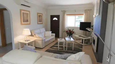 a living room with a white couch and a tv at LakeView Boavista in Lagos