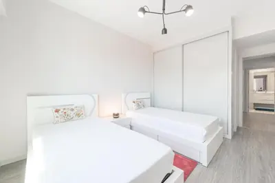 a white bedroom with two beds and a mirror at Getaway to Blue Paradise at Madeira Island in Funchal