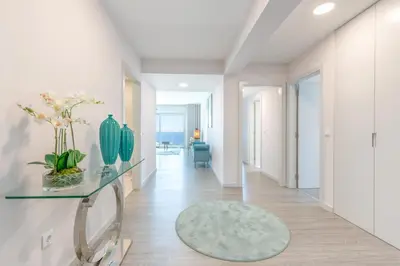a hallway with white walls and a glass table with flowers on it at Getaway to Blue Paradise at Madeira Island in Funchal