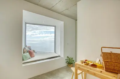 a window in a white room with a table and a bench at Socalco Nature Calheta in Calheta