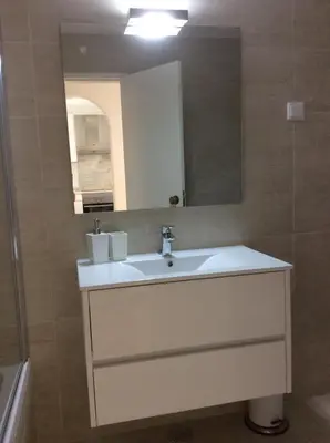 a bathroom with a sink and a mirror at Beach front/waterside apartment in Luz