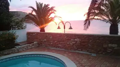 a swimming pool with a view of the ocean at Beach front/waterside apartment in Luz