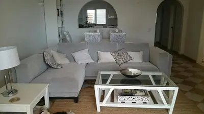 a living room with a gray couch and a table at Beach front/waterside apartment in Luz