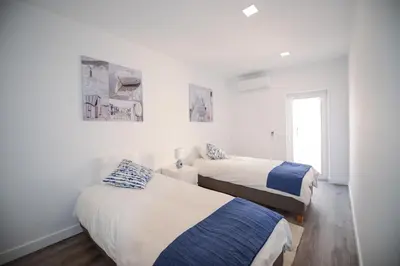 two beds in a room with white walls at SEAFRONT LUZ APARTMENT in Luz