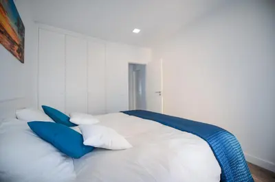 a bed with blue and white pillows on it at SEAFRONT LUZ APARTMENT in Luz