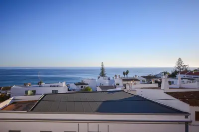 a view of the roof of a house with the ocean in the background at SEAFRONT LUZ APARTMENT in Luz